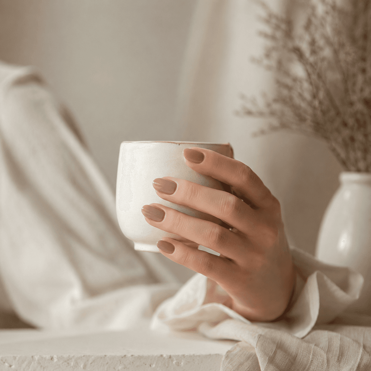 コーヒーカップを持つ手元のライフスタイル